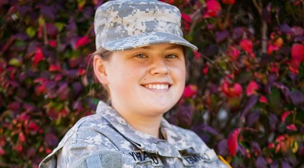 student posing and smiling in military uniform 